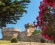 Castle of Populonia with pink flowers on the righthand side. Blue sky with various bushes and trees.