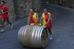 two mean pushing a botte up the hill in Montepulciano