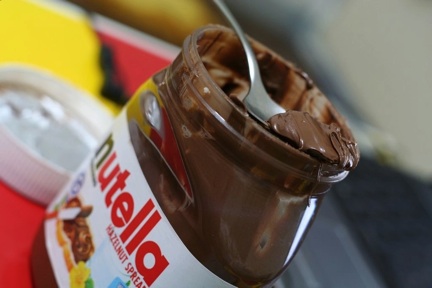jar of nutella with spoon taking a scoop out of it